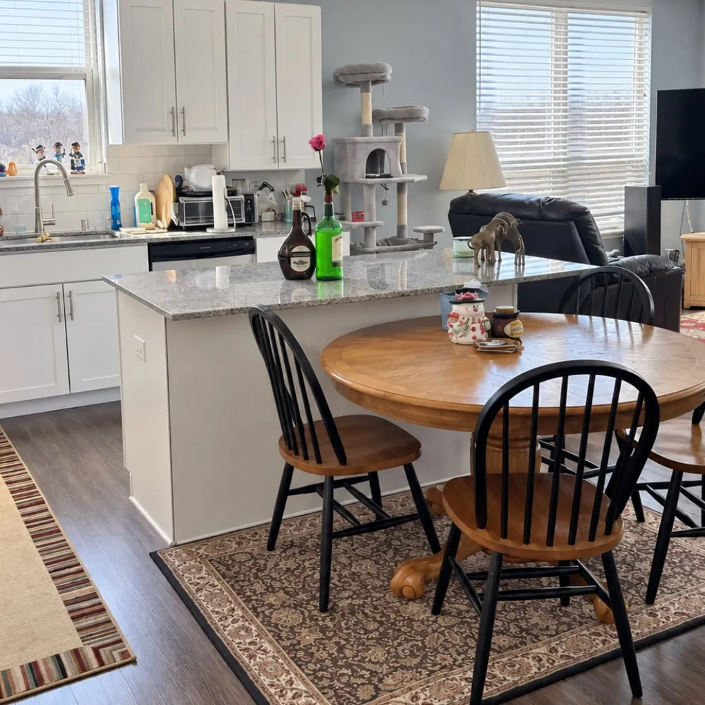 The same kitchen and dining area after cleaning, with clear, spotless surfaces